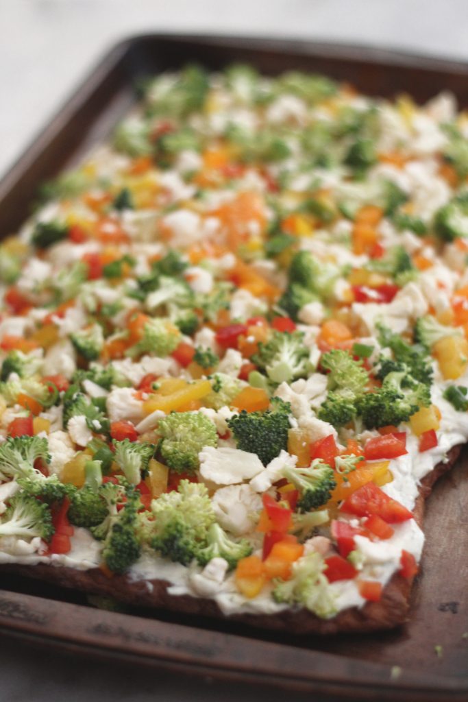 Looking for a yummy but low carb appetizer? Look no further! This low carb cold veggie pizza recipe is a healthier take on a traditional carb laden recipe! #lowcarb #keto #vegetables #fathead #lowcarbappetizer #cauliflower #broccoli #bellpeppers #ranch